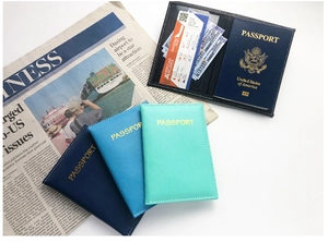 Slim PU leather passport covers in dark blue and cyan shown with travel documents