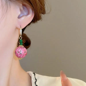 Vintage palace style earrings with pink glass beads and golden hooks on a model