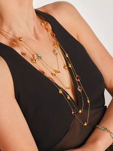 Détail d'un collier multicouche en acier doré orné de pierres en verre tchèque