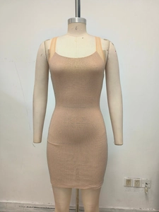 Gros plan d'une robe moulante beige ornée de strass avec des fines bretelles
