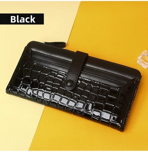 Detail of long black leather wallet with matte finish and embossed crocodile texture