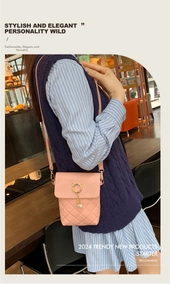 Pink quilted phone bag with gold cat clasp and pearl tassel detail on model