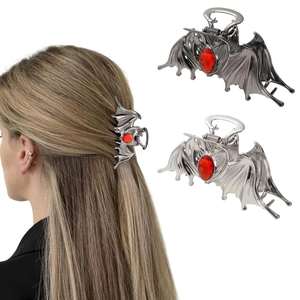 Detail of gothic bat hair claw with red ruby inlay in silver and black metal finishes