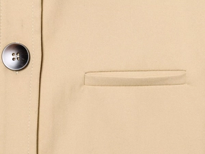 Detail of khaki twill fabric with a premium dark button and elegant welt pocket design
