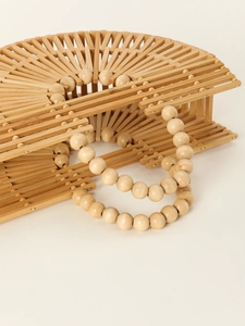 Detail of the semi-circular hollow woven bamboo handbag with a beaded handle design