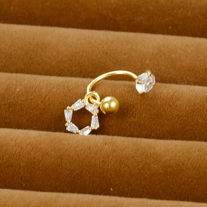 Macro shot of gold C-shaped earring with hexagonal zircon pendant on brown velvet