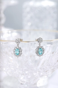 Detail of blue Paraiba-style earrings with halo diamond setting on glass rim