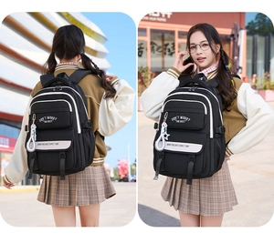 Detail of black nylon student backpack with white contrast lines and slogans