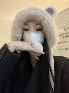 Close-up of plush bear ear hood with integrated long scarf in soft creamy white fleece