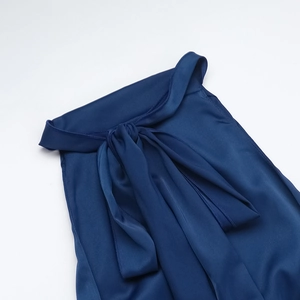 Détail d'une robe élégante en satin bleu marine avec un grand nœud attaché au col du dos