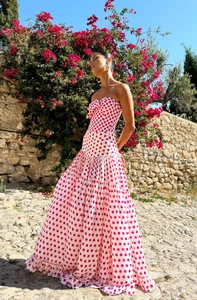 Detail of a strapless white maxi dress with pink polka dots and bow detail on the bust