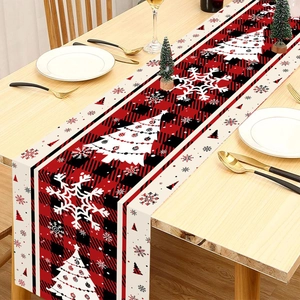 Red and black plaid Christmas table runner with white pine trees on a wooden table