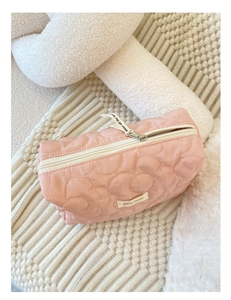 Vue détaillée de la trousse matelassée rose avec fermeture éclair et étiquette logo