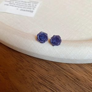 Macro des boucles d'oreilles rose en résine violette avec détails de pétales mats