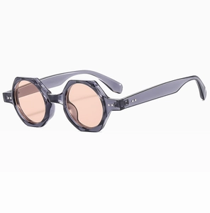 Detail of polygonal translucent grey sunglasses with orange lenses and silver rivets
