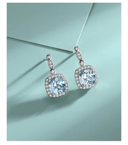 Detailed macro view of S925 sterling silver drop earrings with light blue square gemstones