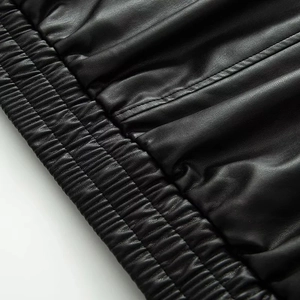 Macro detail of elastic waistband and stitching on black leather jacket for women
