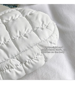 Detail of white quilted nylon fabric texture with neat square stitching on chest bag