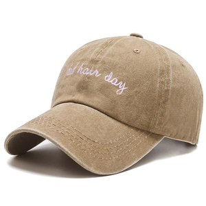 Detail view of khaki washed cotton baseball cap with pink bad hair day embroidery