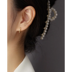 Elegant gold S925 silver huggie hoop earrings with inset diamonds worn by a model