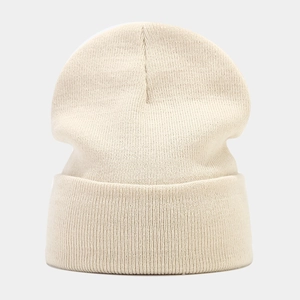 Detailed close-up of ribbed texture and beige knit fabric on winter beanie hat