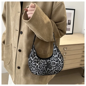 Detail of trendy leopard print crescent bag with black and white texture on model arm