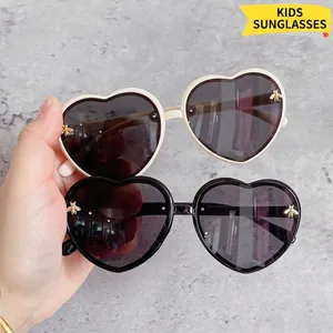 Cute heart-shaped children sunglasses with glitter frames and small gold bee details