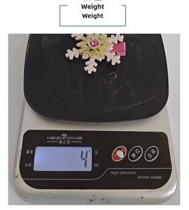 Detail showing a pink snowflake hair clip with rhinestones being weighed on a digital scale