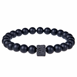 Detail of matte black beads and square porous lava stone on a minimalist beaded bracelet