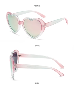 Detail view of heart-shaped sunglasses with pink and cyan gradient frames and colorful lenses