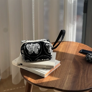 Detailed embroidery of white butterflies on premium black canvas hand bag