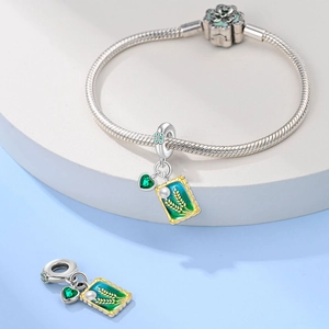 Detail of silver snake chain bracelet with green rectangle wheat charm and pearl