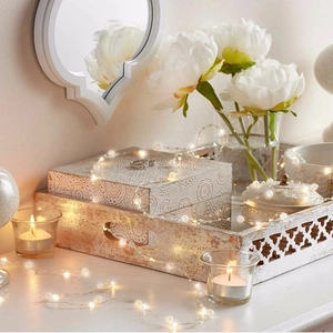 Dettaglio di luci a LED in filo di rame con perle su un tavolo da trucco