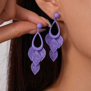 Detail shot of purple matte drop leaf earrings with delicate cutout bohemian fringe