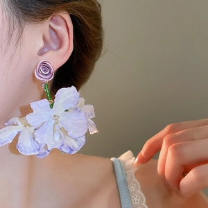Detail of purple fabric flower tassel earrings with green beads and water drop pendant