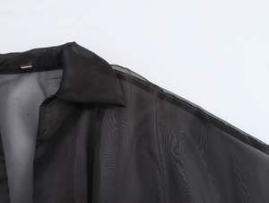 Gros plan du décolleté en V élégant avec empiècement en organza sur robe noire chic
