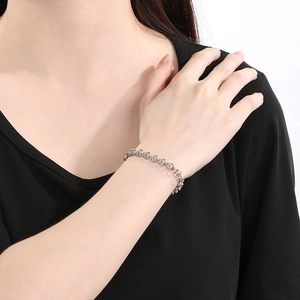 Gros plan d'un bracelet gourmette en acier inoxydable argenté porté par une femme