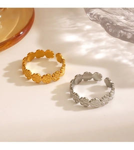 Detailed view of interconnected flower patterns on adjustable gold and silver rings