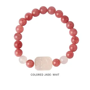 Close-up of strawberry crystal beaded bracelet with rectangular jade charm on white background