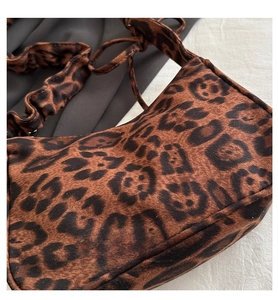 Dettaglio borsa leopardata con tessuto strutturato e tracolla a increspatura