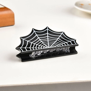 Detail of black bat-shaped hair claw clip with white spider web print for Halloween