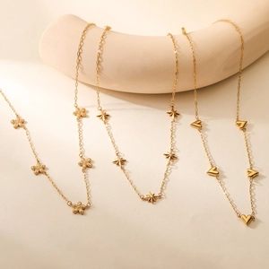 Minimalist gold necklaces featuring heart, star, and flower pendants on a beige background