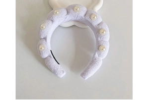 Detail of light purple plush headband featuring imitation pearls and soft wave texture