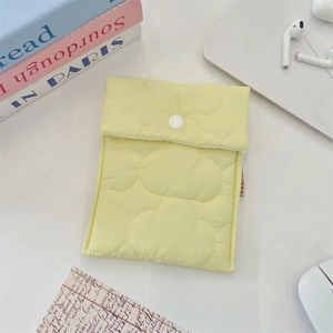 Macro detail of soft quilted yellow storage pouch with cloud stitching and button closure