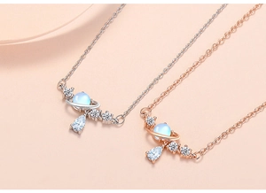 Close-up of planet pendant necklaces with cat-eye stone and teardrop zircon accents