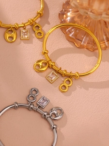 Detail of 18k gold and silver bangles with figure-8 and zirconia stone charms
