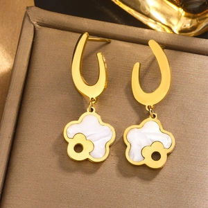Macro shot of 18K gold plated titanium earrings with white shell flower pendants