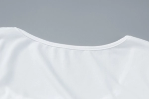Détail du col rond et des coutures de qualité sur cette robe blanche élégante