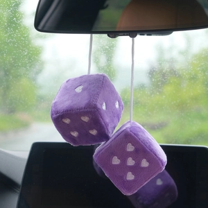 Purple plush dice car charms with heart patterns hanging on a rearview mirror