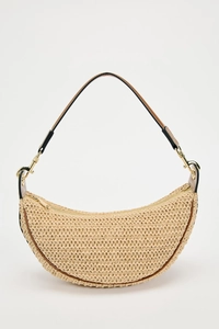 Detailed close-up of woven beige straw hobo bag with brown leather strap and gold hardware